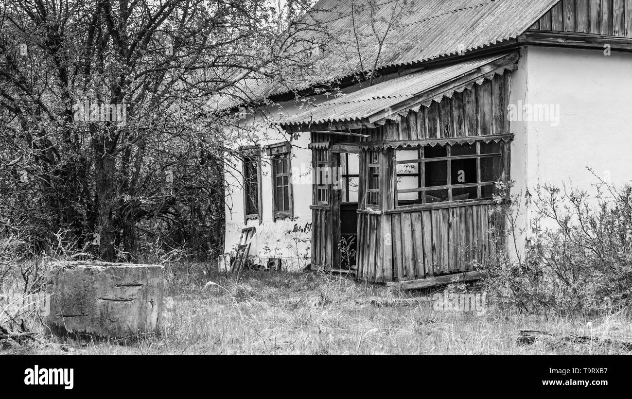Maison cassée abandonnée en noir et blanc dans la zone d'exclusion de Tchernobyl en Biélorussie Banque D'Images