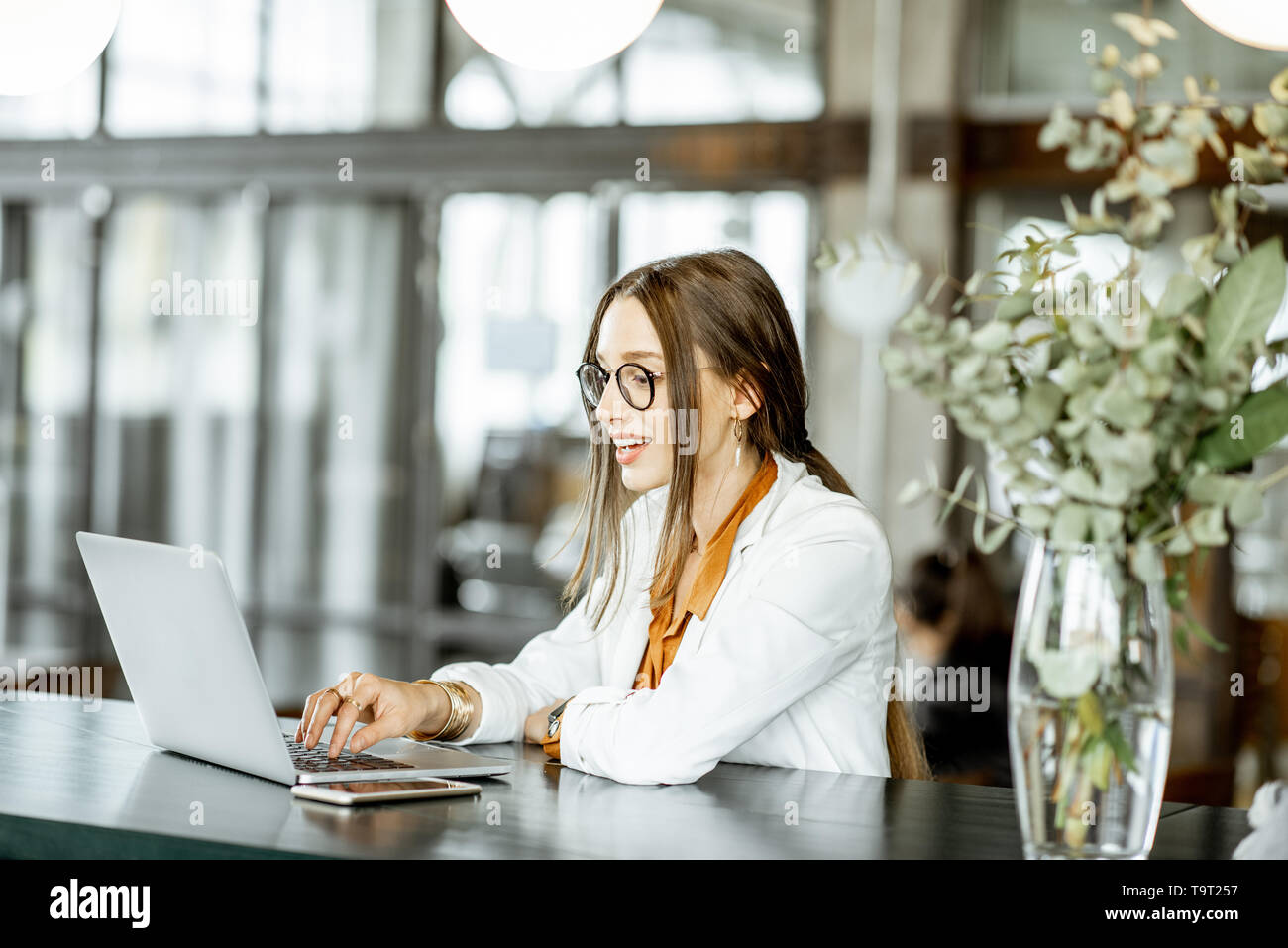 Portrait d'une jeune femme d'affaires et d'un pointage à l'ordinateur moderne le grand bar ou bureau Banque D'Images