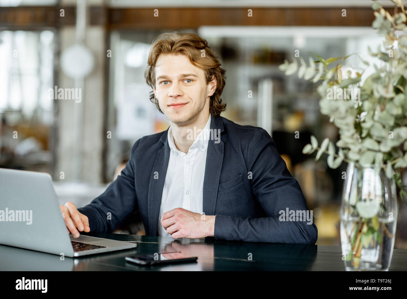Portrait of a young handsome man portable au bar moderne et spacieuse ou bureau Banque D'Images
