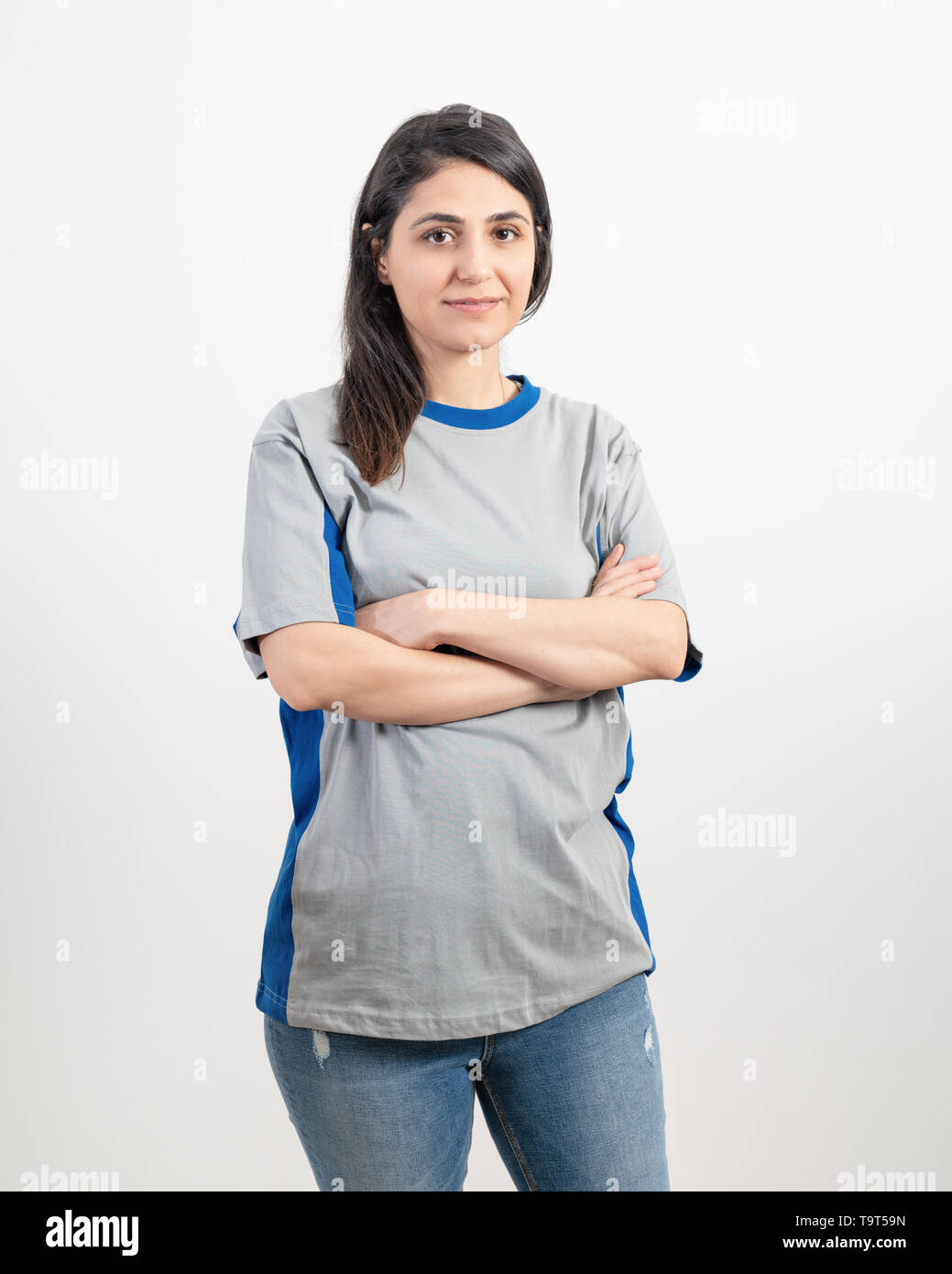 Jeune fille vierge portant des T-shirt gris et un jean bleu. Fond de mur gris . Banque D'Images