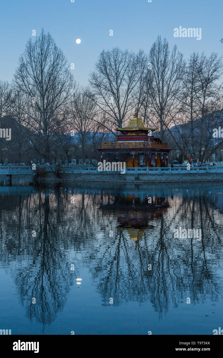 L'aube d'une image de la lune au cours d'une petite pagode au bord du lac dans la place du Potala à Lhassa, au Tibet. Banque D'Images