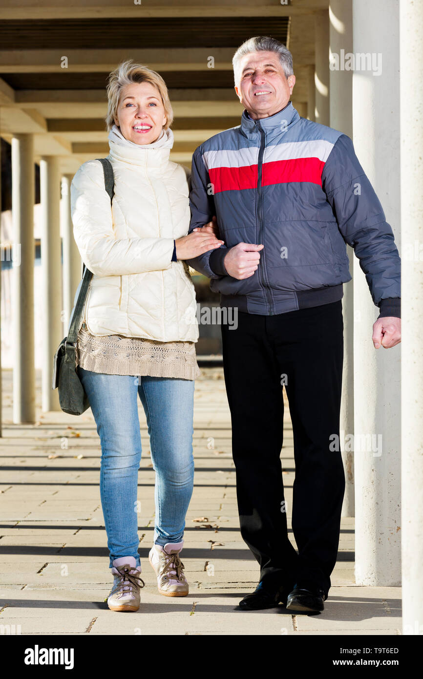 Couple positif va pour marcher entre les piliers en béton sur sunny day Banque D'Images