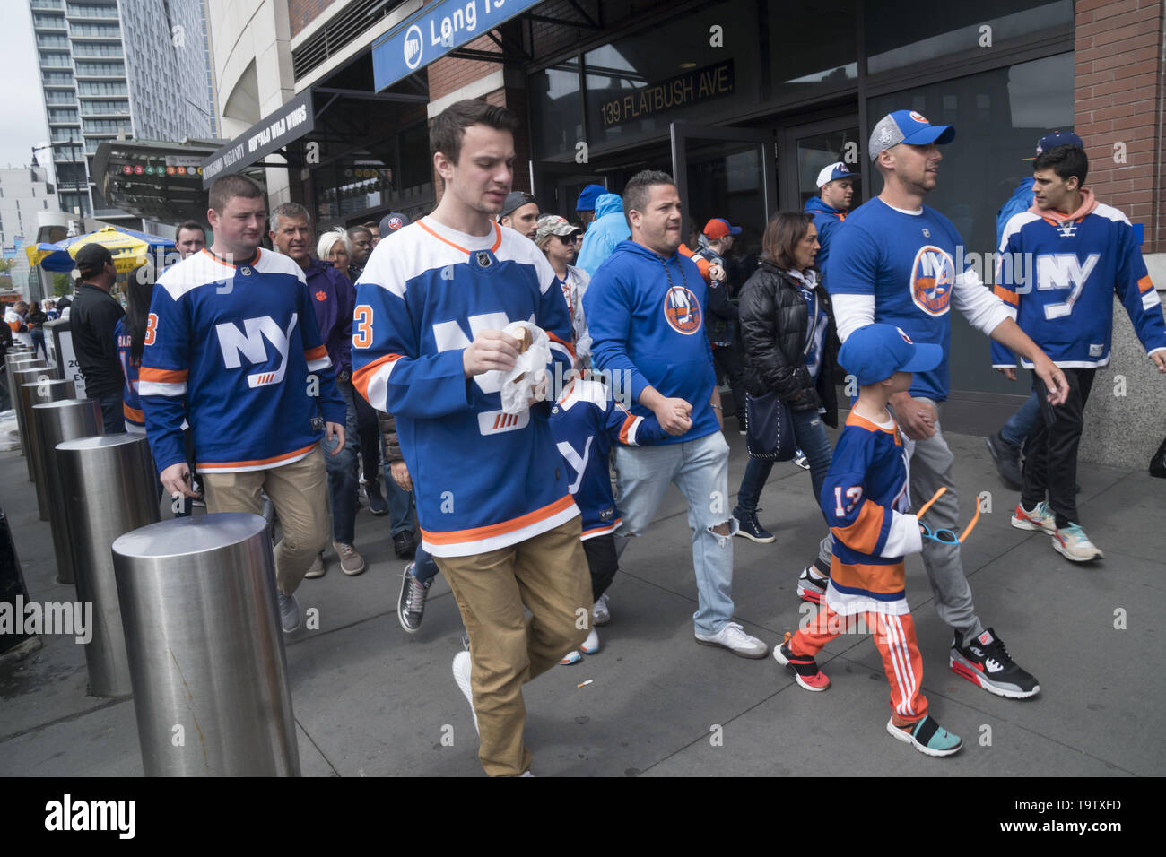 Les fans des New York Rangers dévoués marchent de la station LIRR aux éliminatoires de la coupe Stanley au Barklays Center de Brooklyn, New York. Banque D'Images