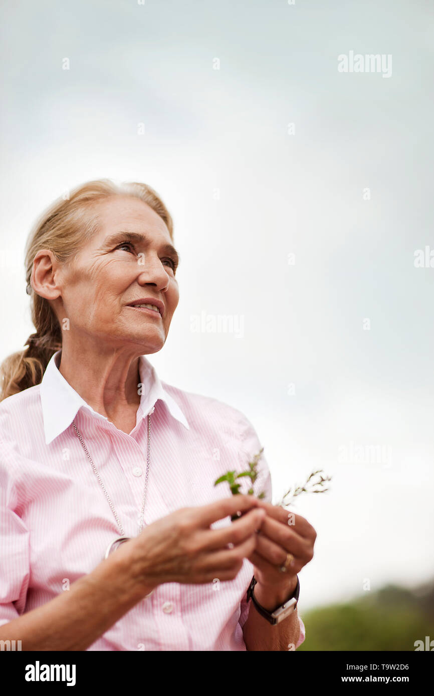 Portrait de femme tenant un vigneron jeune plant. Banque D'Images