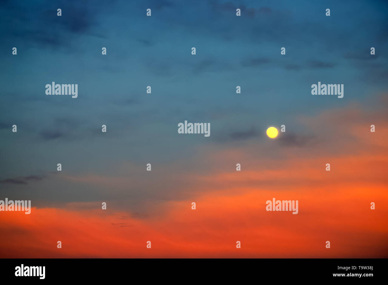Pleine lune pittoresque sur fond de beaux nuages bleu et rouge. Nuages au coucher du soleil, le lever du soleil dans la pleine lune. Fond de nuage, l'espace texte. Banque D'Images