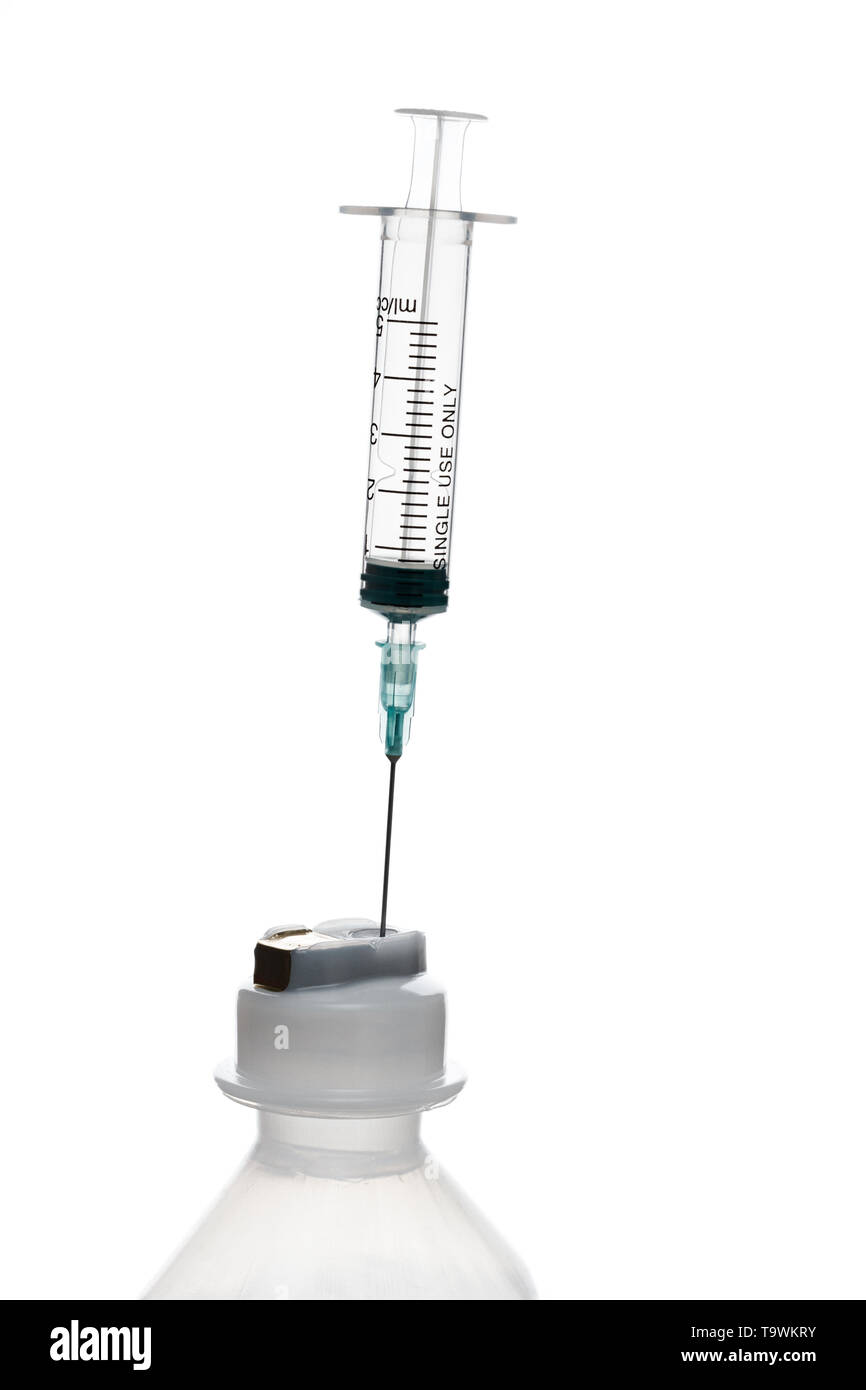 Seringue vide pour injection avec un cou d'une bouteille en plastique sur un fond blanc. Banque D'Images