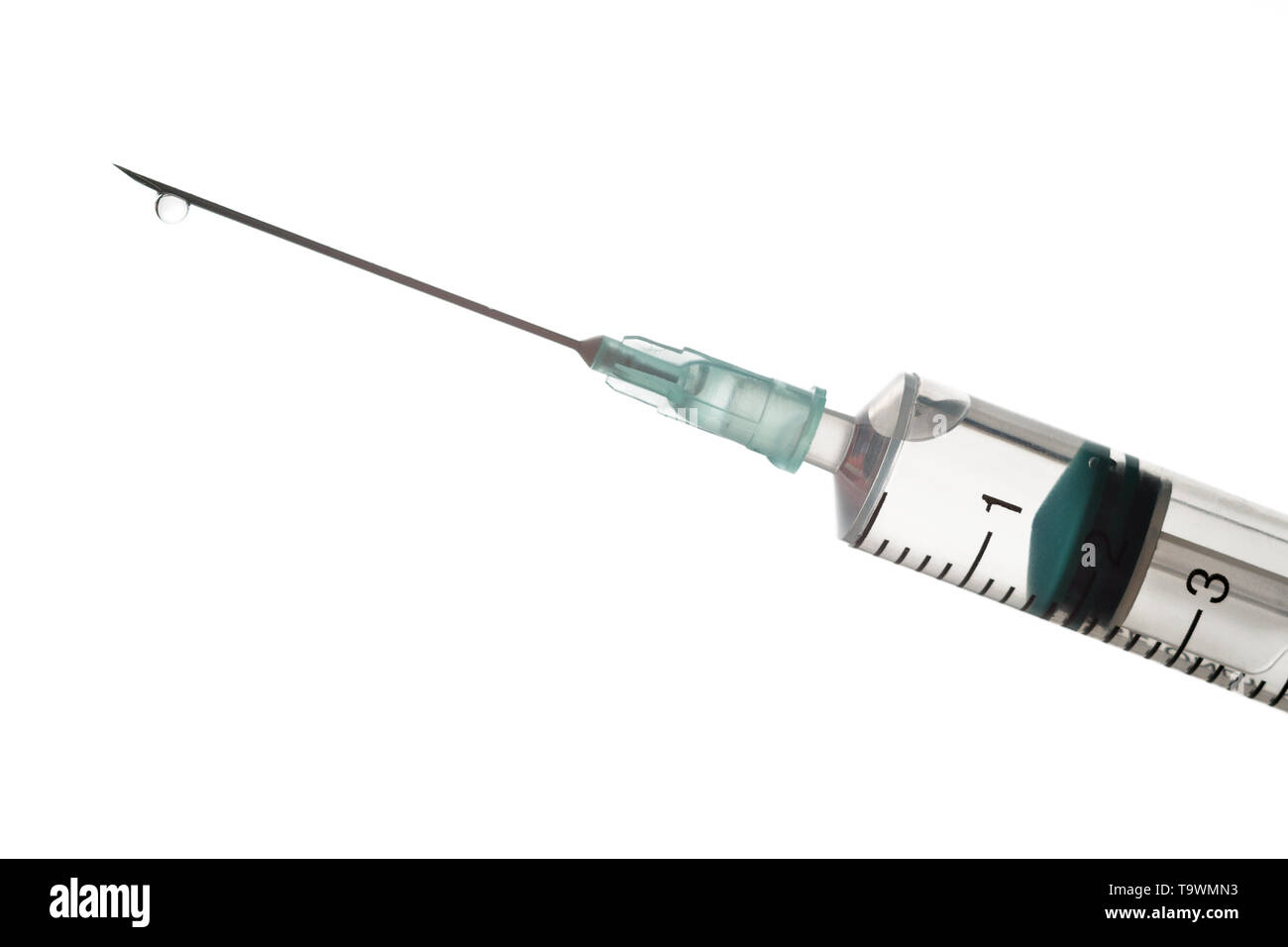 L'extrémité de la seringue avec une aiguille remplie de liquide sur un fond clair. Banque D'Images