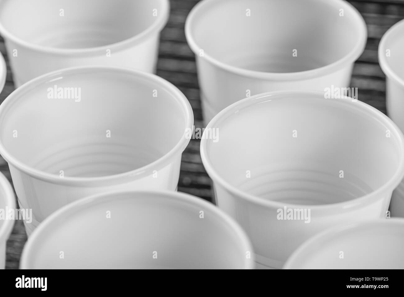 Un groupe de gobelets en plastique blanc fixé sur un tableau noir. Photo gros plan macro Banque D'Images