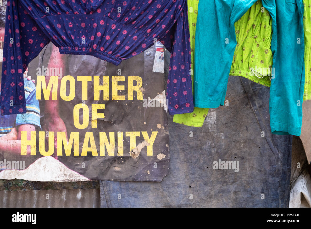 Mère de l'humanité politique marketing poster est visible sur le mur, derrière la ligne de séchage du linge. Dhaka, Bangladesh. Banque D'Images