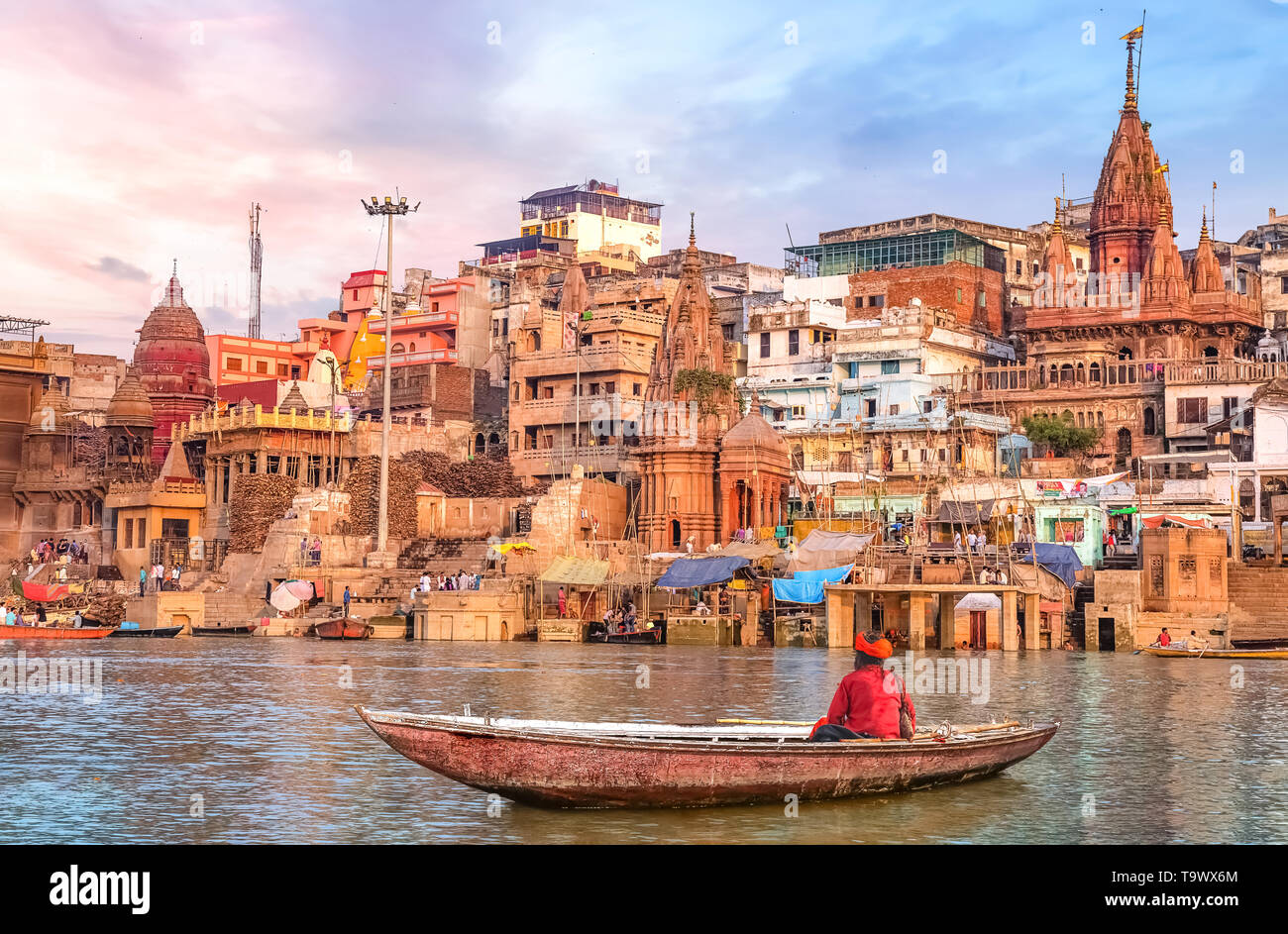 L'architecture ancienne Varanasi ville au coucher du soleil avec vue sur sadhu baba bénéficiant d'une promenade en bateau sur le Gange. Banque D'Images