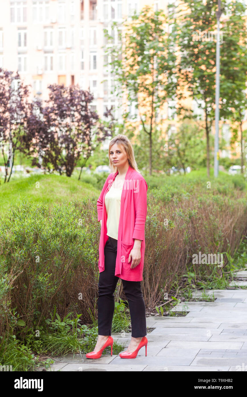 Portrait de jeune femme sérieuse belle réussite dans le style élégance debout sur Green Park, posant avec un visage confiant et regarder Banque D'Images