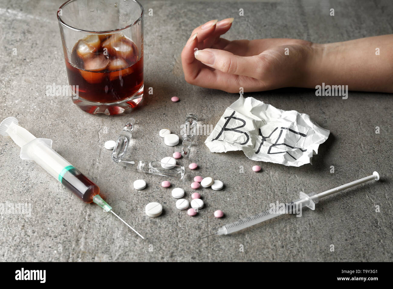 La femelle, seringue, pilules et verre d'alcool sur le tableau gris. Notion  de suicide Photo Stock - Alamy