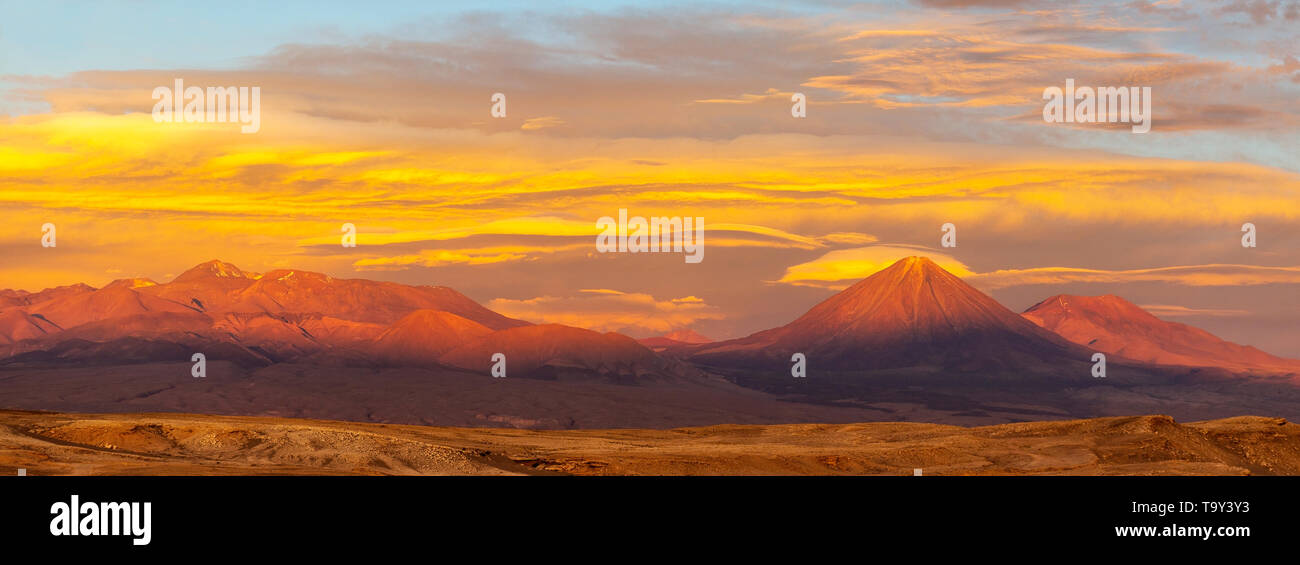 Photographie panoramique du désert d'Atacama avec le volcan Licancabur et pics de montagne des Andes au coucher du soleil près de San Pedro de Atacama, au Chili. Banque D'Images