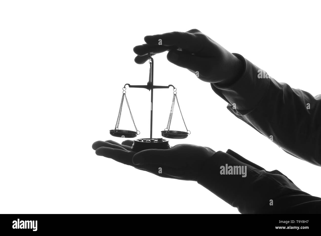 Silhouette d'homme les mains avec balance de la justice sur fond blanc Banque D'Images