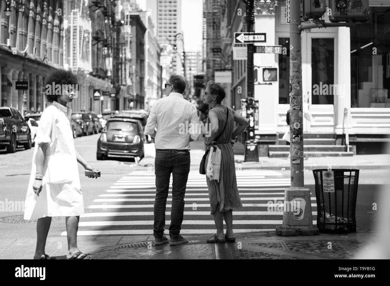 Couple d'âge moyen d'essayer d'obtenir une orientation dans Manhattan avec African American Woman walking down the street. Banque D'Images