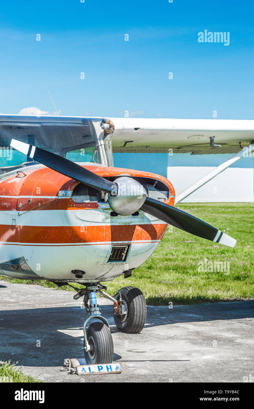 Vue avant du vieux rouge et blanc seul avion à hélice du moteur sur pelouse dans sunshine. Banque D'Images