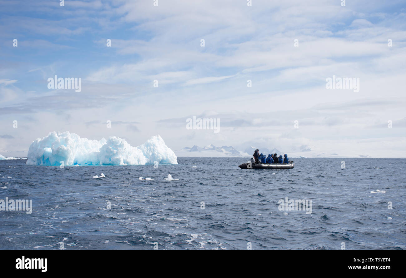 Un groupe de touristes et un pilote sur un Zodiak croisières passé une lumière bleu moyen et iceberg flottant dans l'océan Atlantique Sud près de Chile Banque D'Images
