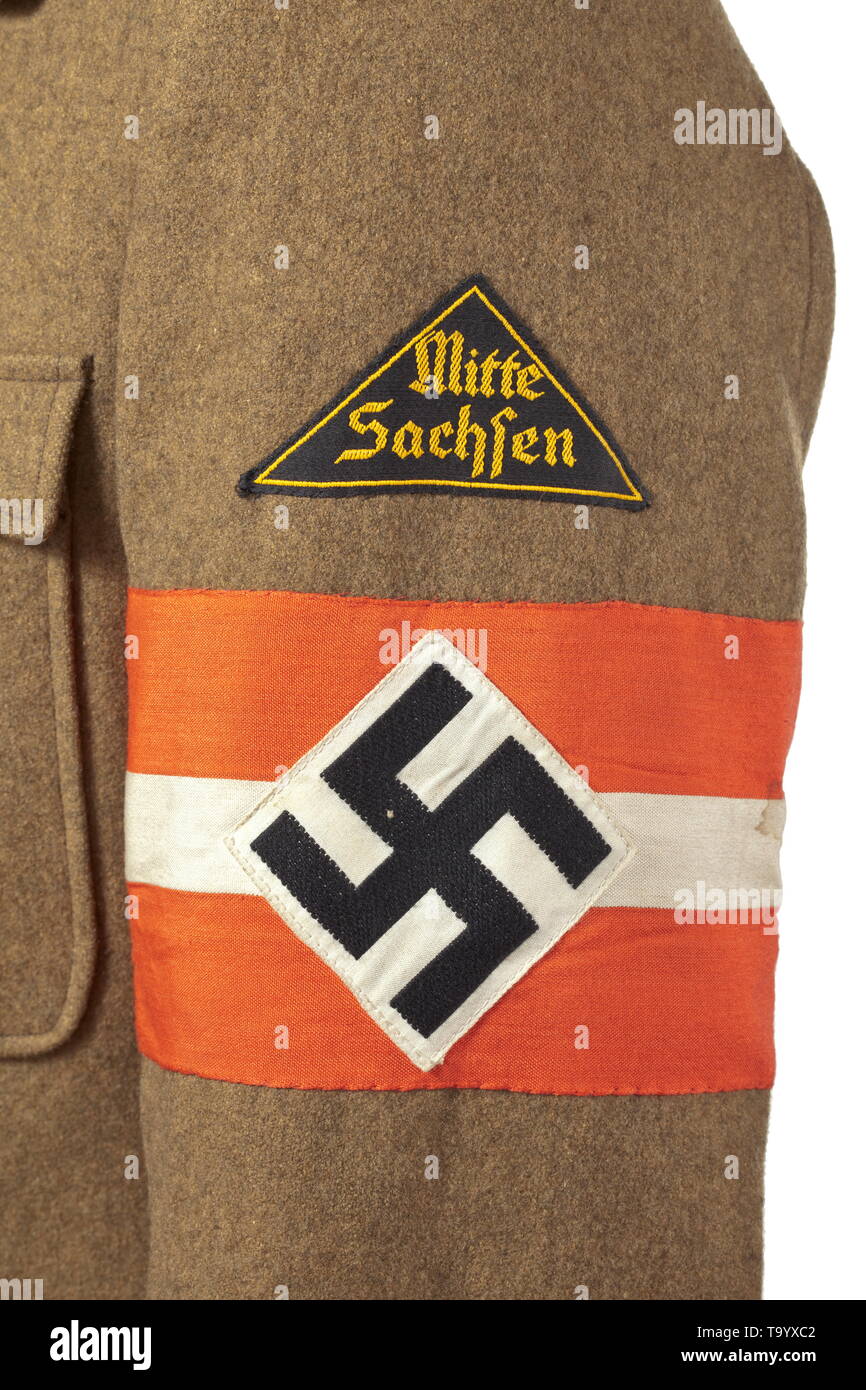 Une veste de service pour un HJ-Oberstammführer dans la région saxe depot morceau avec étiquette RZM laine marron avec boutons gris, incorporated hanger et ouverture à la dague du leader, de soie de couleur olive avec étiquette RZM HJ-Dienstrock «' dans la poche intérieure. Dans l'épaule noir cousus avec corde d'argent, le délignage, quatre étoiles et un rang de métal bande d'argent. Manchon noir cousu avec lettrage jaune triangle tissé 'Mitte Sachsen'., historique, historique du 20e siècle, Additional-Rights Clearance-Info-Not-Available- Banque D'Images