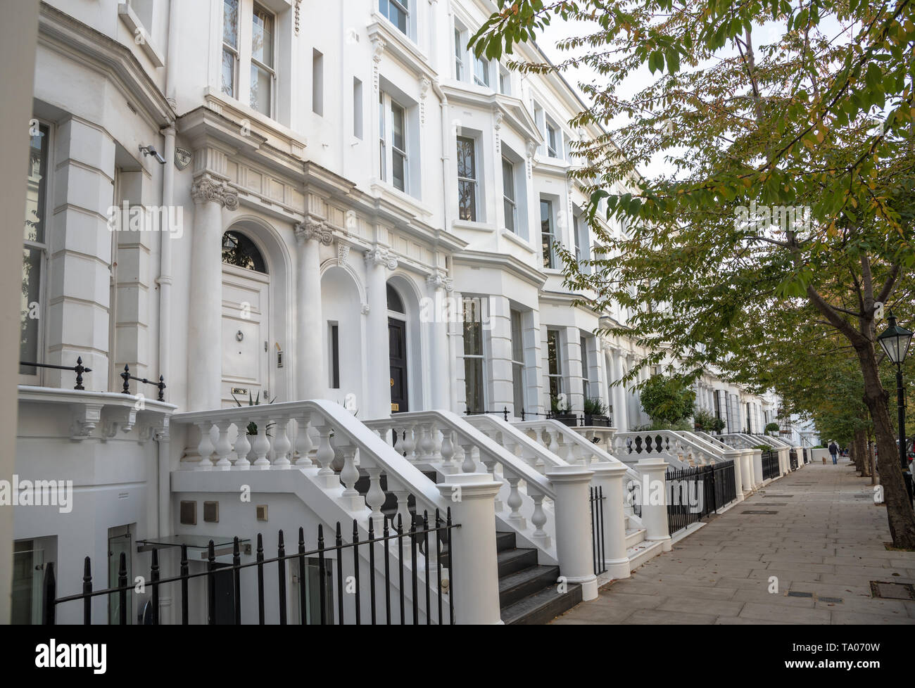 Blanc de luxe Terrasse maisons le long d'une chaussée de pierre bordée d'une journée d'automne. Londres, Royaume-Uni. Banque D'Images