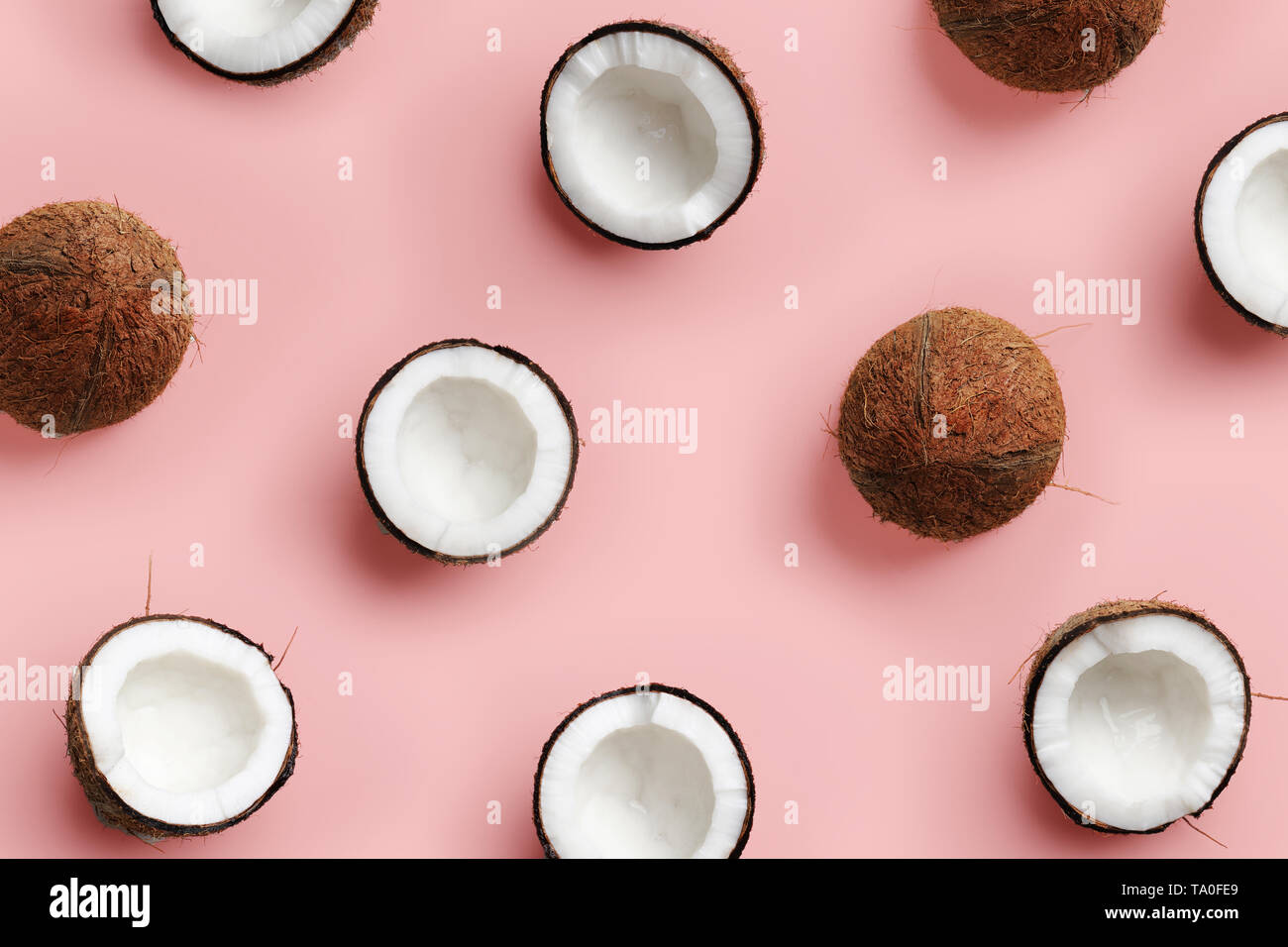 Avec motif sur coco mûre fond rose. Vue d'en haut. Copier l'espace. Pop art design, creative concept d'été. La moitié de la noix de coco dans un minimum de mise à plat Banque D'Images