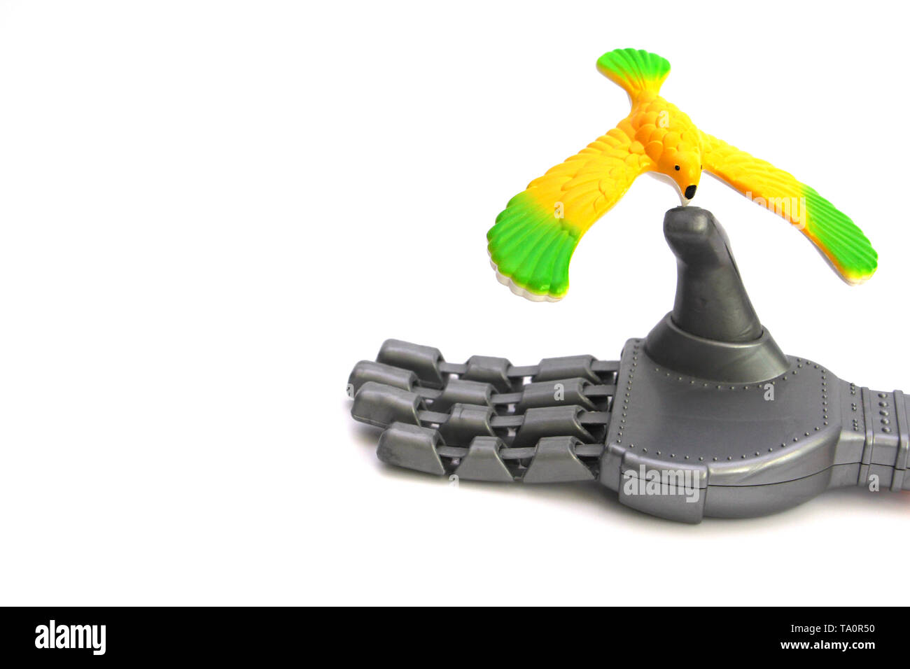 Un petit oiseau est assis sur le doigt d'un robot. L'oiseau est jaune, il n'est pas vivant. La main du robot est un jouet. Le concept de l'amour et la bonté. Banque D'Images