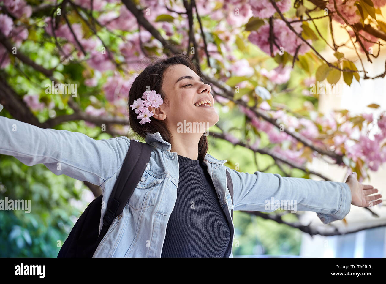 Happy woman Traveler se tient les bras et vous détendre n'hésitez pas avec les fleurs de cerisier ou sakura fleur arbre en vacances Banque D'Images
