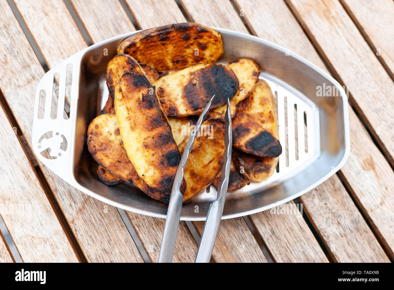 Close up de légumes grillés - pommes de terre - et d'une fourchette sur une table en bois Banque D'Images