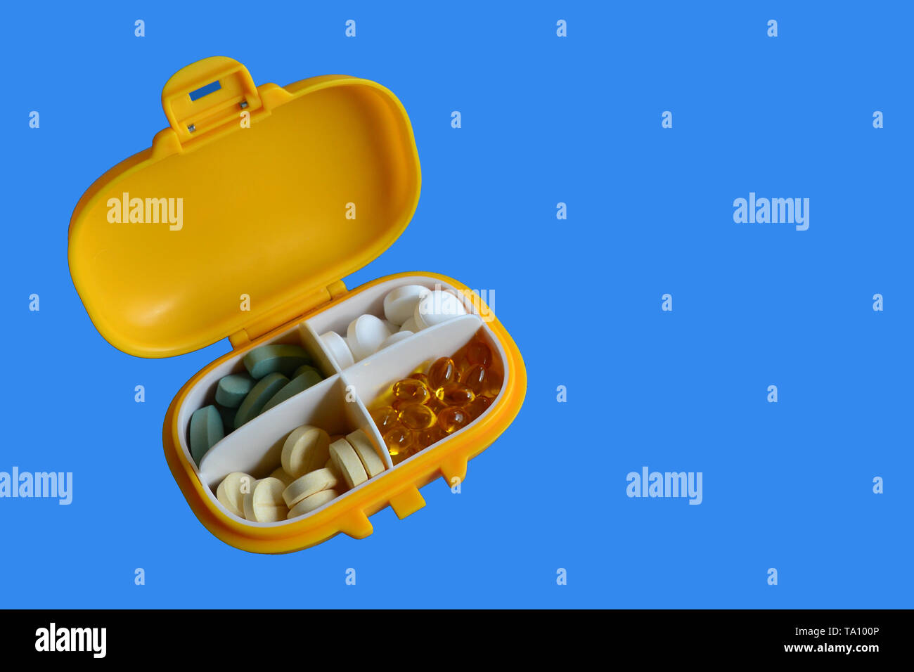 Médicament en plastique jaune contenant avec pills sur fond bleu. Copier l'espace. Isolé Banque D'Images