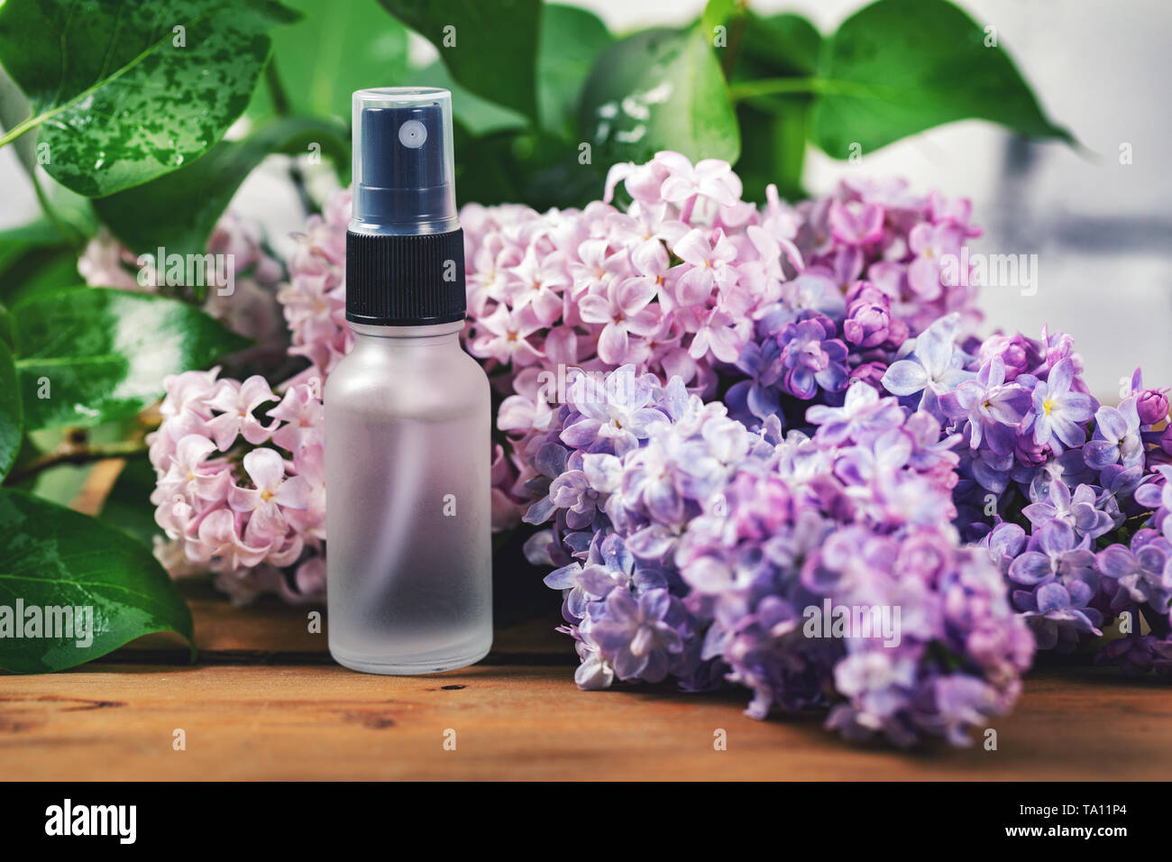 Flacon pulvérisateur avec fleurs et parfum lilas Banque D'Images