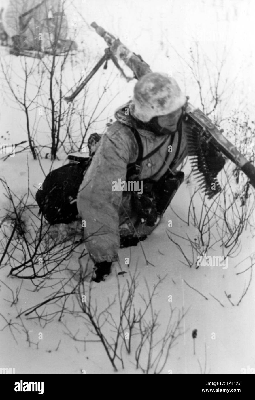 Un soldat allemand a coulé jusqu'aux genoux dans la neige. Le mitrailleur de la SS est situé près de la ville de Toropez. Photo de l'entreprise de propagande (PK) : SS correspondant de guerre des touffes. Banque D'Images