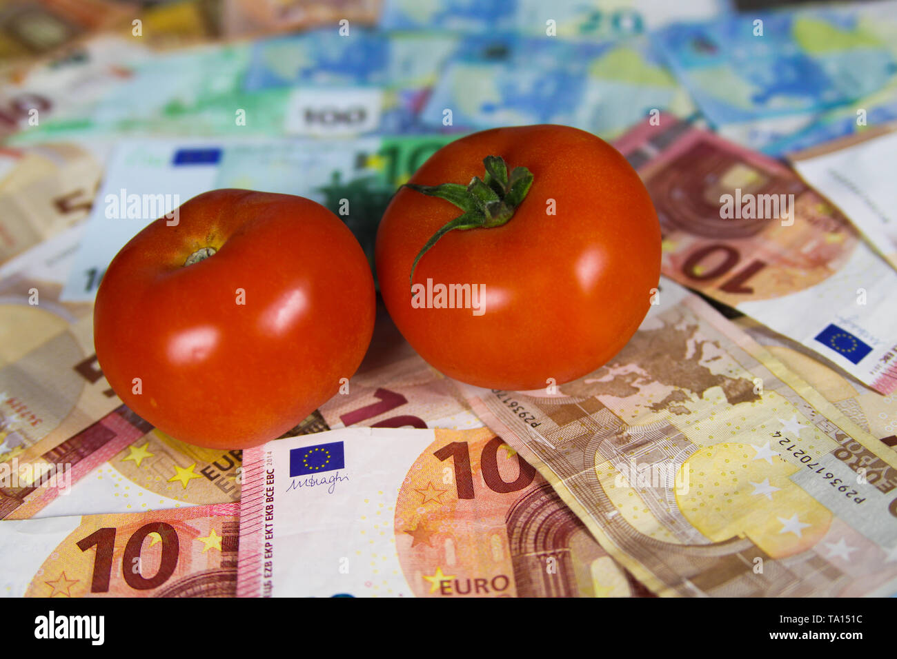 Le coût de la nutrition saine et équilibrée - Deux tomates sur le papier-monnaie euro bank notes Banque D'Images
