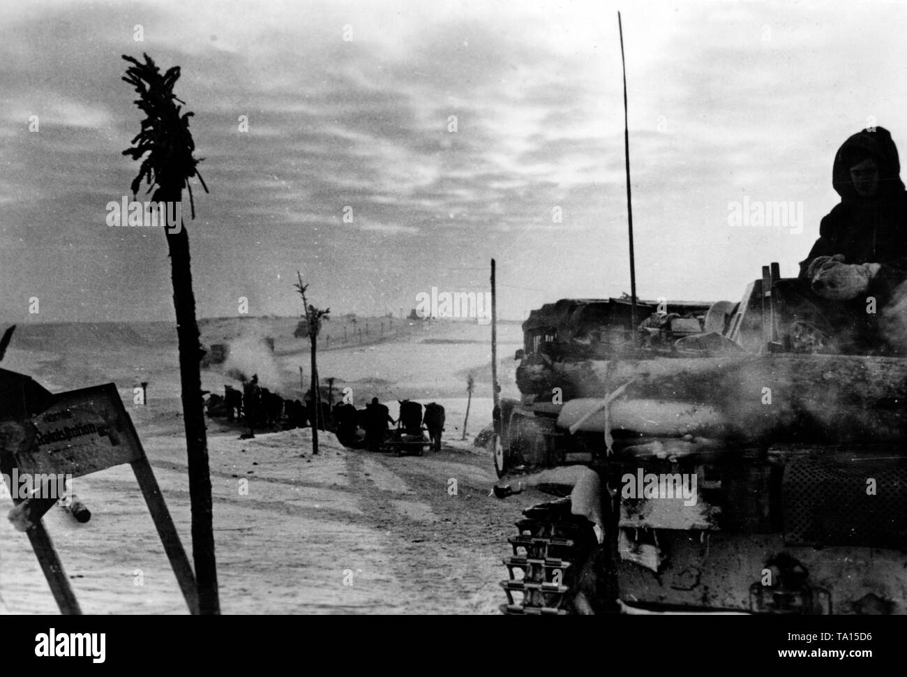 Un char à boeufs et plusieurs en voiture le long d'une route le long du front de l'Est. Le panneau sur la gauche indique la prochaine station de radio. Photo de l'entreprise de propagande (PK) : correspondant de guerre Maltry. Banque D'Images