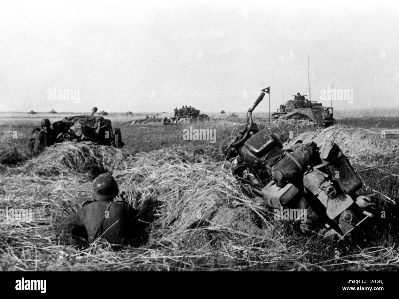 Les chars allemands lors d'une attaque sur les plaines de la région d'Orel (OREL). Au premier plan, un fantassin assis dans un trou de fusil, une moto (probablement une Victoria KR 25 / W) et un canon antichar (probablement une 7,5 cm PaK 40). Plus loin sur la photo, une rangée de chars allemands. Photo de l'entreprise de propagande (PK) : correspondant de guerre Schaefer. Banque D'Images