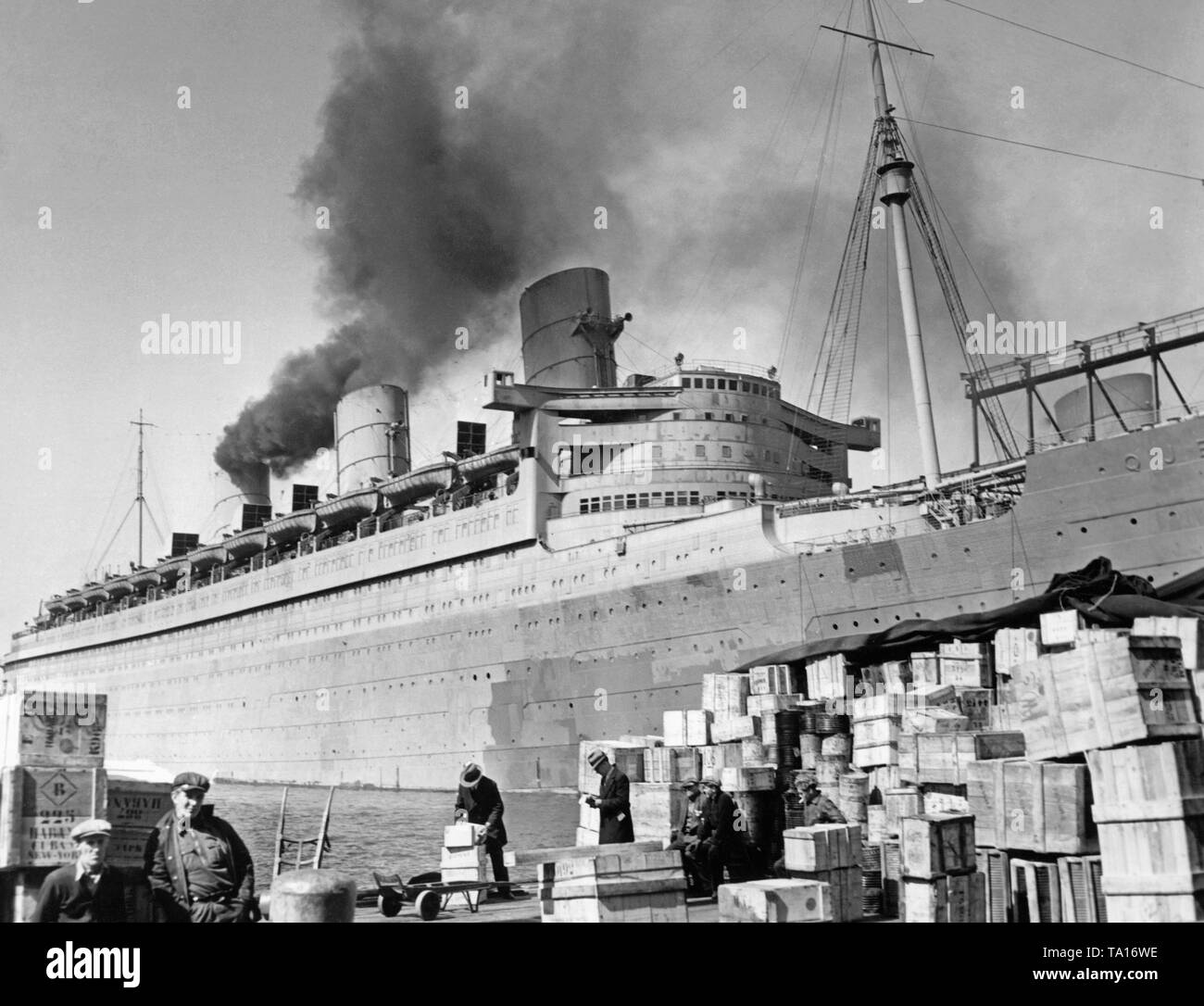 Le "Queen Mary" avec la peinture de camouflage et converti en transport de troupes est ancrée dans le port de New York. Banque D'Images