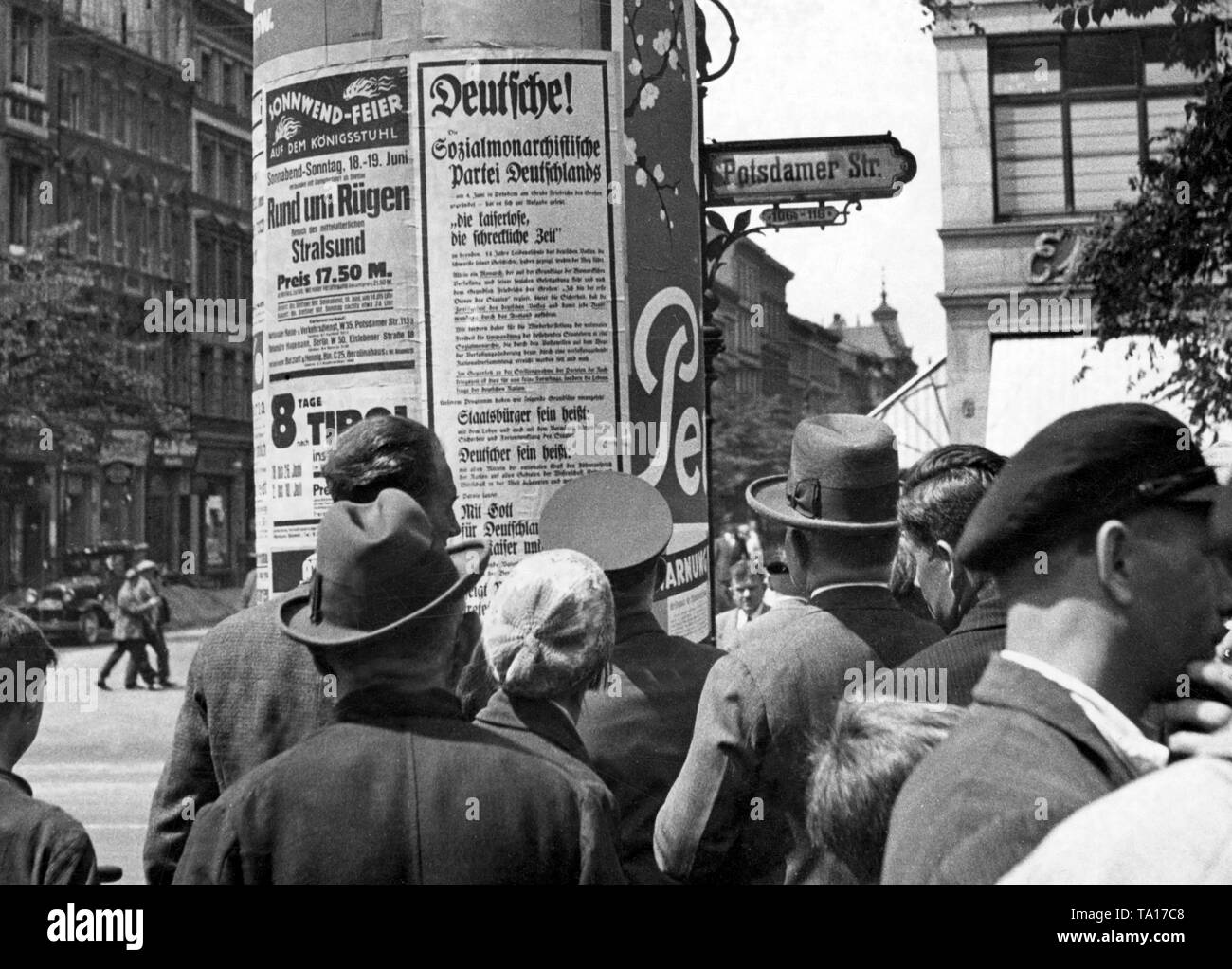 Les passants regarder l'affiche électorale du parti monarchiste Social de l'Allemagne à une colonne dans la publicité de la Potsdamer Strasse. Banque D'Images