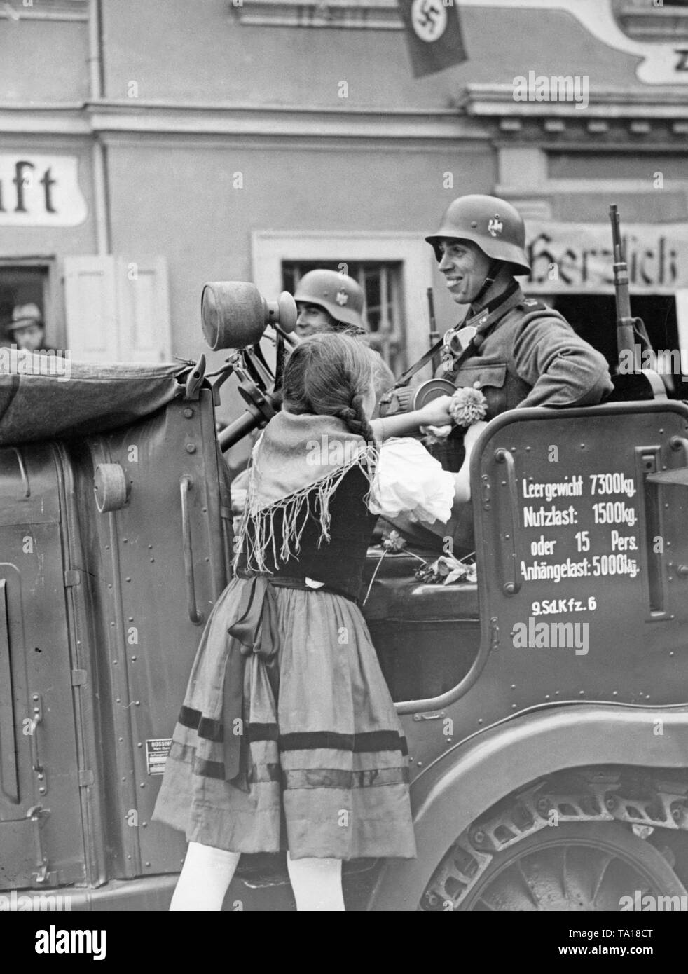 Bâtons d'une fille une fleur sur un uniforme de soldat le 3 octobre 1938, dans Grottau (aujourd'hui Hradek nad Nisou). Les soldats sont assis dans un Zugmaschine Sdkfz. Buessing (AG). Banque D'Images