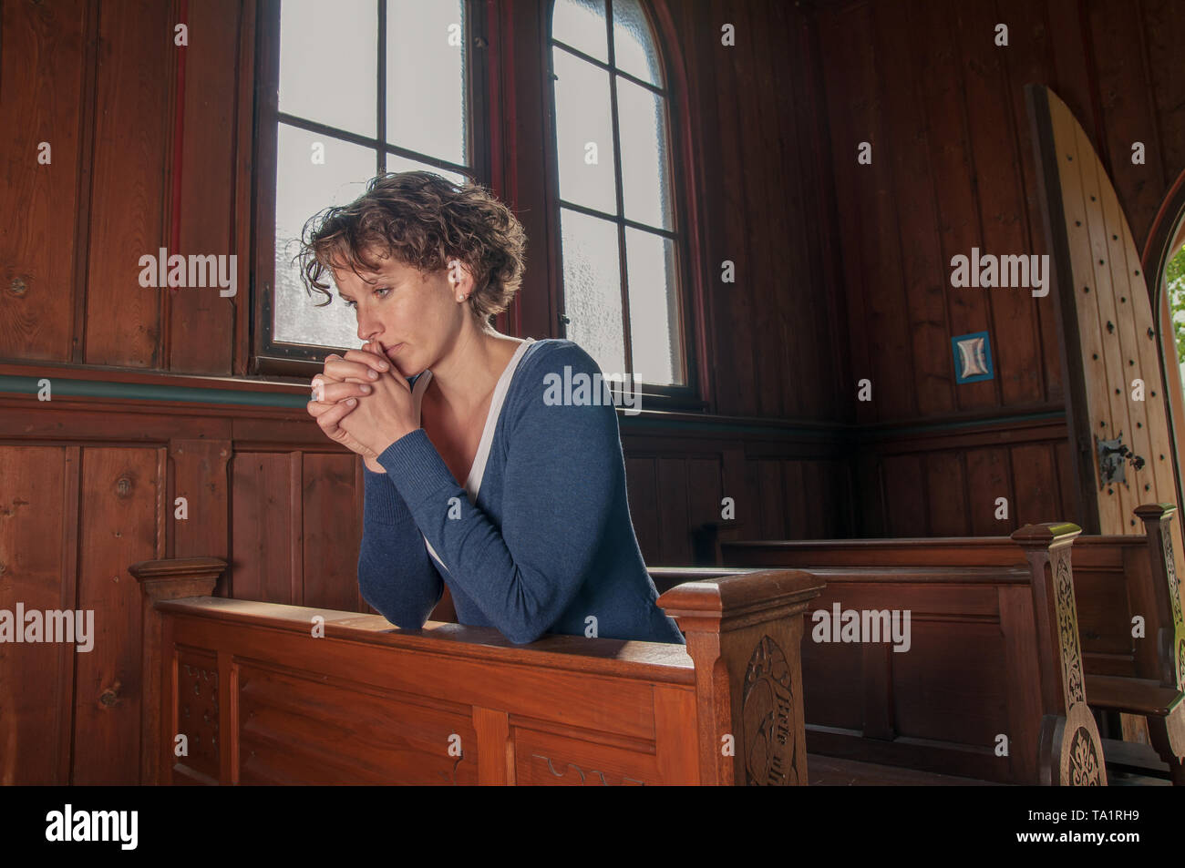 Jeune femme prie à l'église Banque D'Images