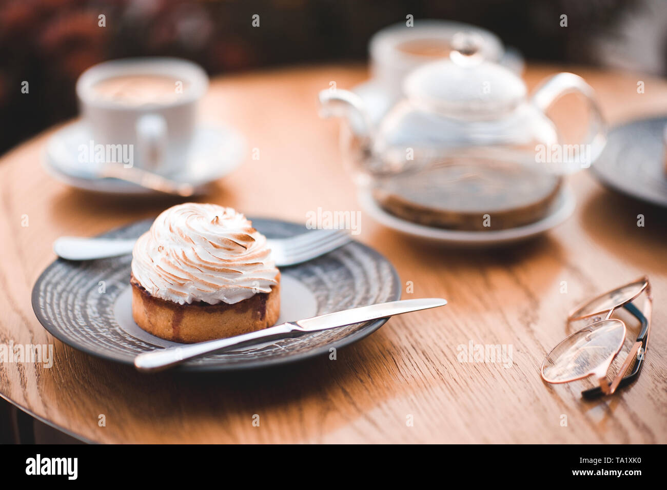 Délicieux gâteau crémeux avec théière et tasse de thé sur la table en bois en gros plan cafe. Banque D'Images