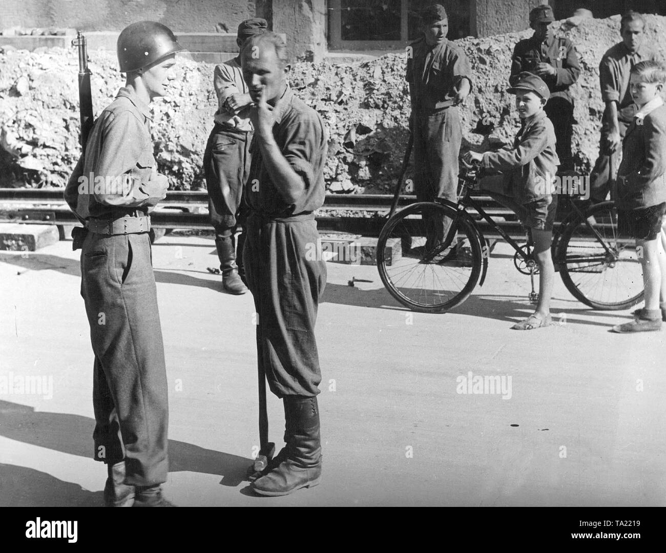 Un Américain à la garde des soldats allemands qui sont occupés avec le nettoyage après la guerre à Munich. Banque D'Images