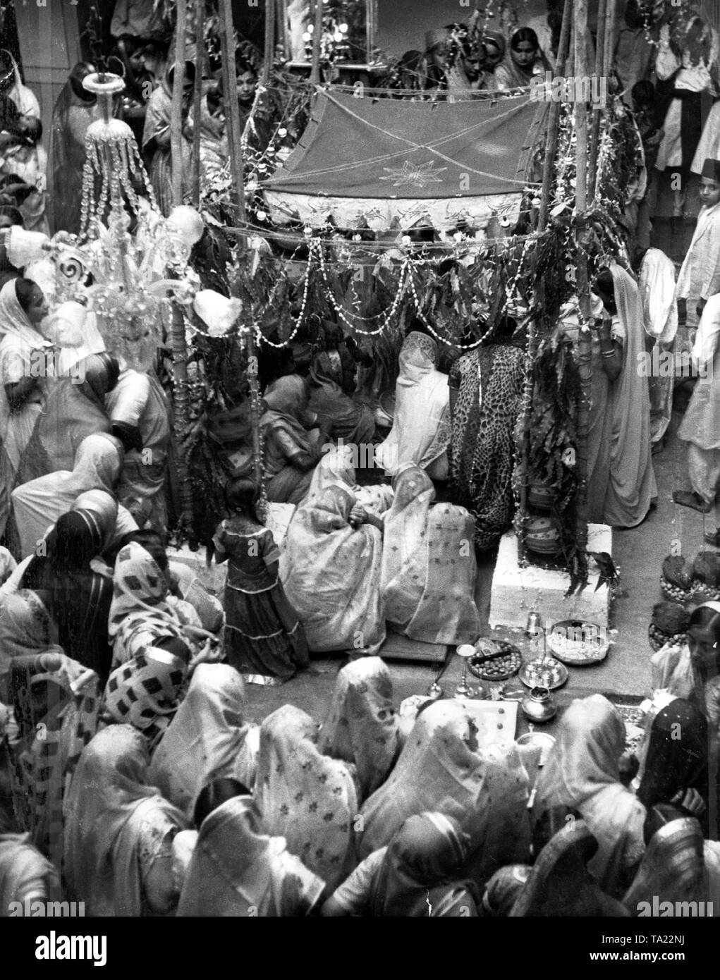 Lors d'un mariage indien, le jeune couple se situe sous la tente de mariage rouge et or, où la cérémonie du mariage est effectué par un prêtre avant le feu sacré. Banque D'Images