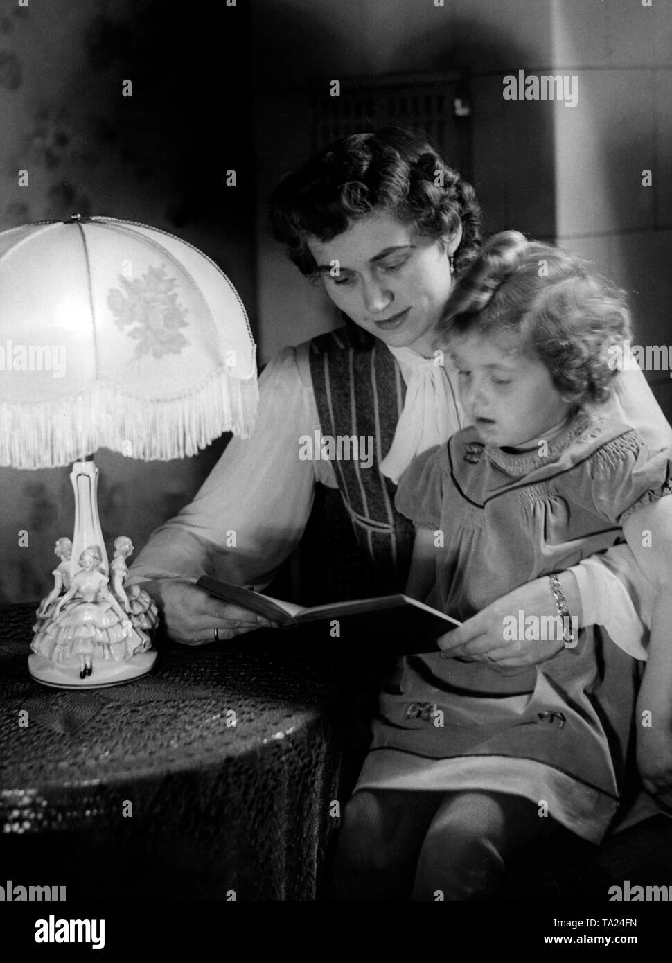 Une mère est la lecture à haute voix à son enfant. Le plus désespéré de la guerre, et le pire de la défaite, plus les machines de propagande nazie a essayé d'imprimer des images de propagande d'un monde pacifique, bien protégés d'origine. Photo : Hoffmann Banque D'Images