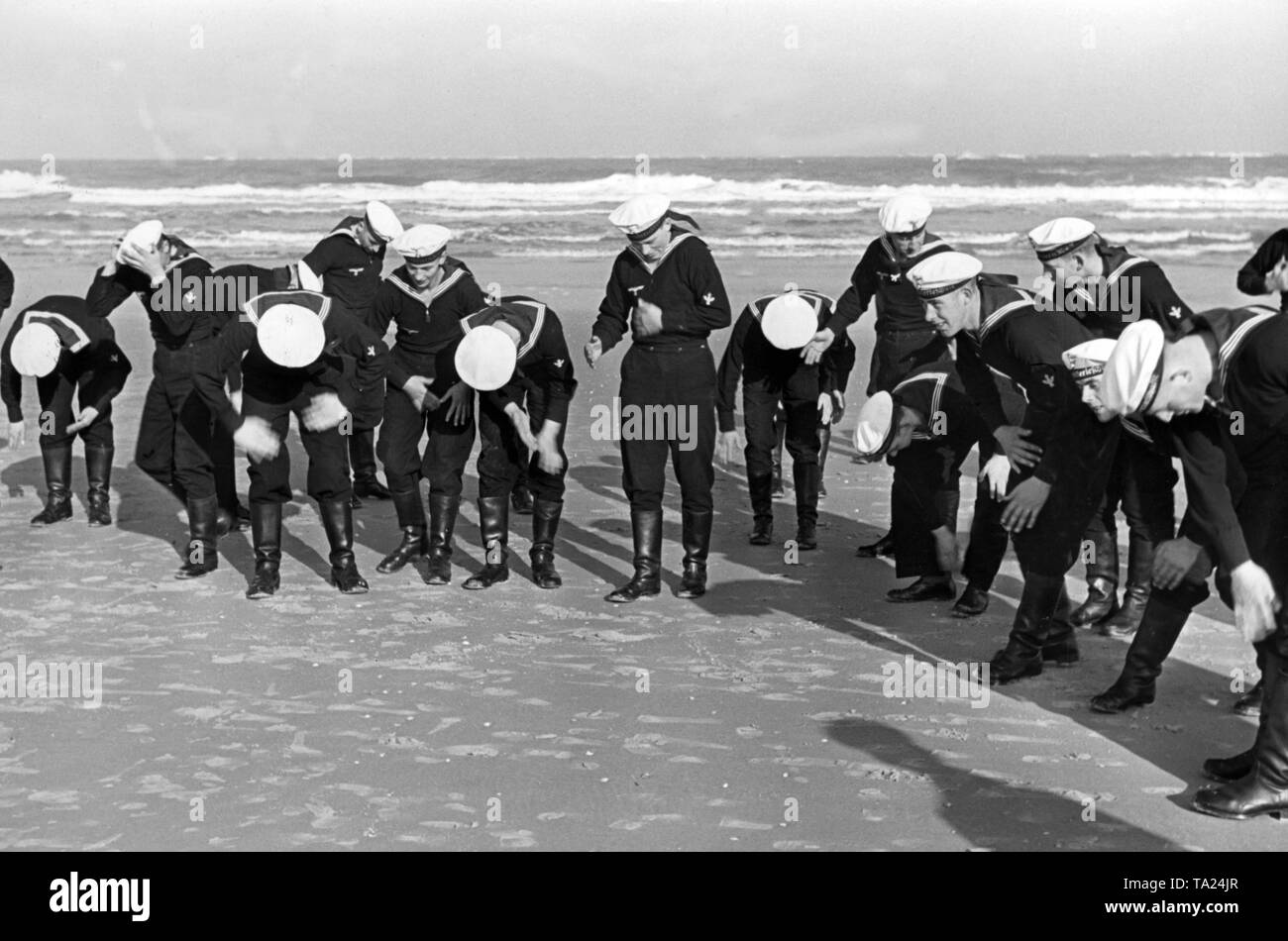 Après avoir pratiqué sur une plage à Norderney, les recrues sont jeter du sable et des petits moules de leurs uniformes. Banque D'Images