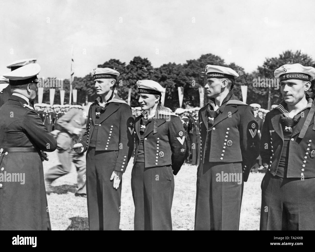 Grand Amiral Erich Raeder (à gauche) rend hommage à la libération des marins (marins) du croiseur allemand « Deutschland de la Kriegsmarine, qui ont combattu dans la guerre civile espagnole, à Doeberitz, près de Berlin, le 5 juin 1939. Dans l'arrière-plan, un photographe radar à travers la photo. Banque D'Images