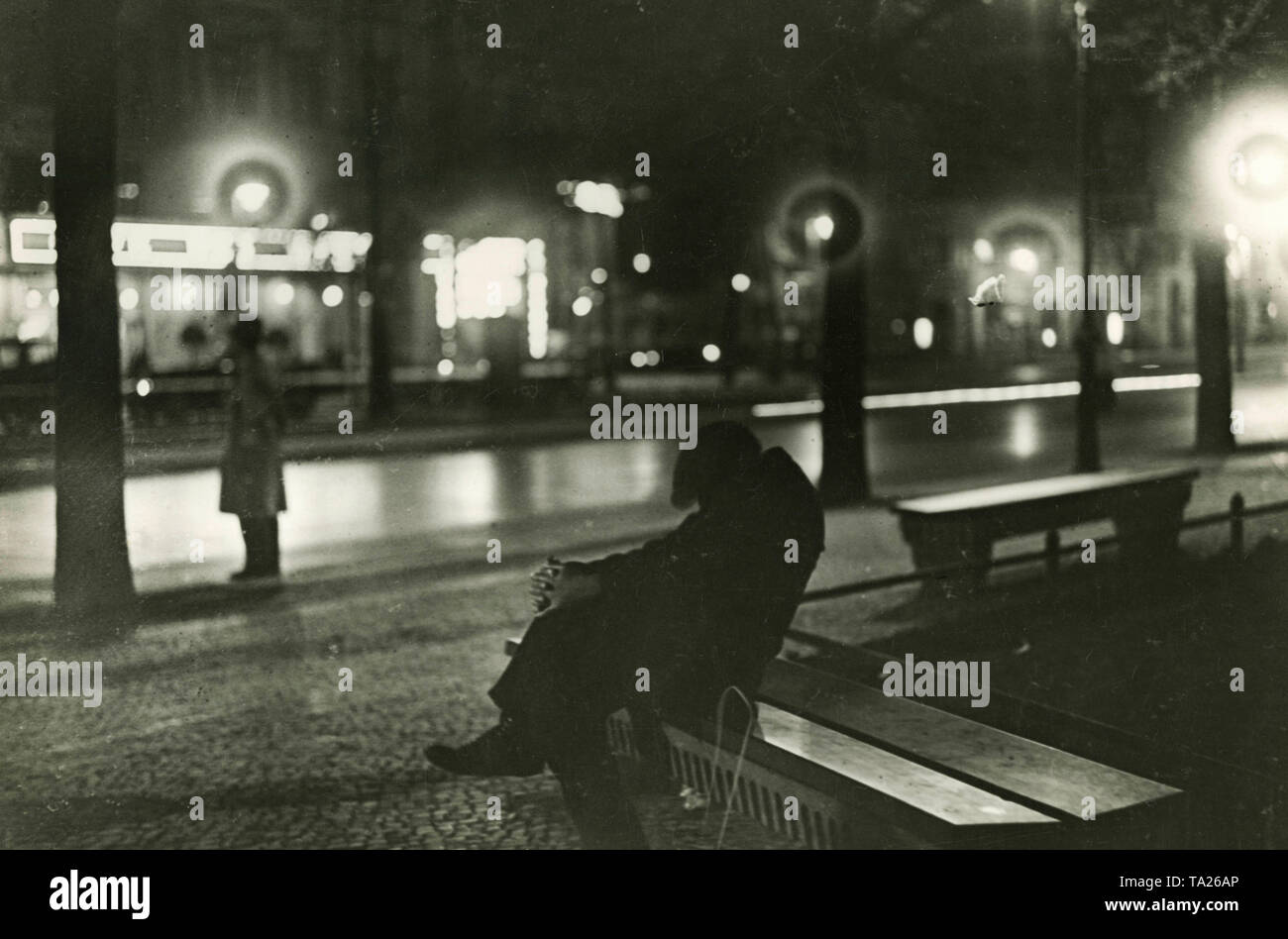 Un chômeur est assis sur un banc de parc. Dans les années de la grande dépression il s'agit d'une photo. Compte tenu de six millions de chômeurs, l'état de l'aide sociale n'est plus suffisant. Banque D'Images