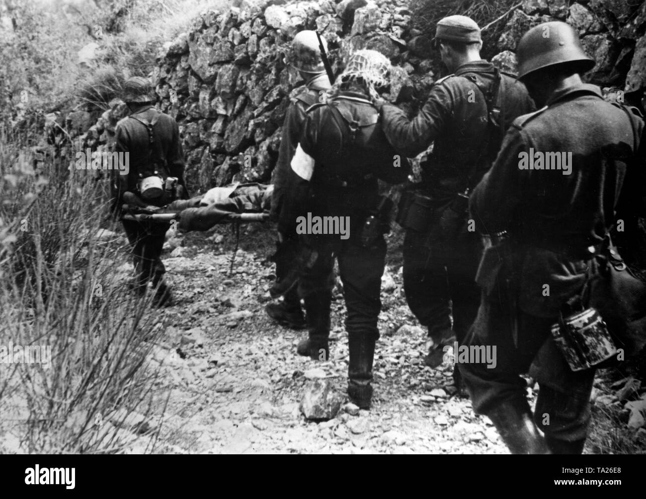 Les soldats allemands portent un camarade blessé en bas de la pente à la poste de secours. Photo de l'entreprise de propagande (PK) : correspondant de guerre Gebauer. Banque D'Images