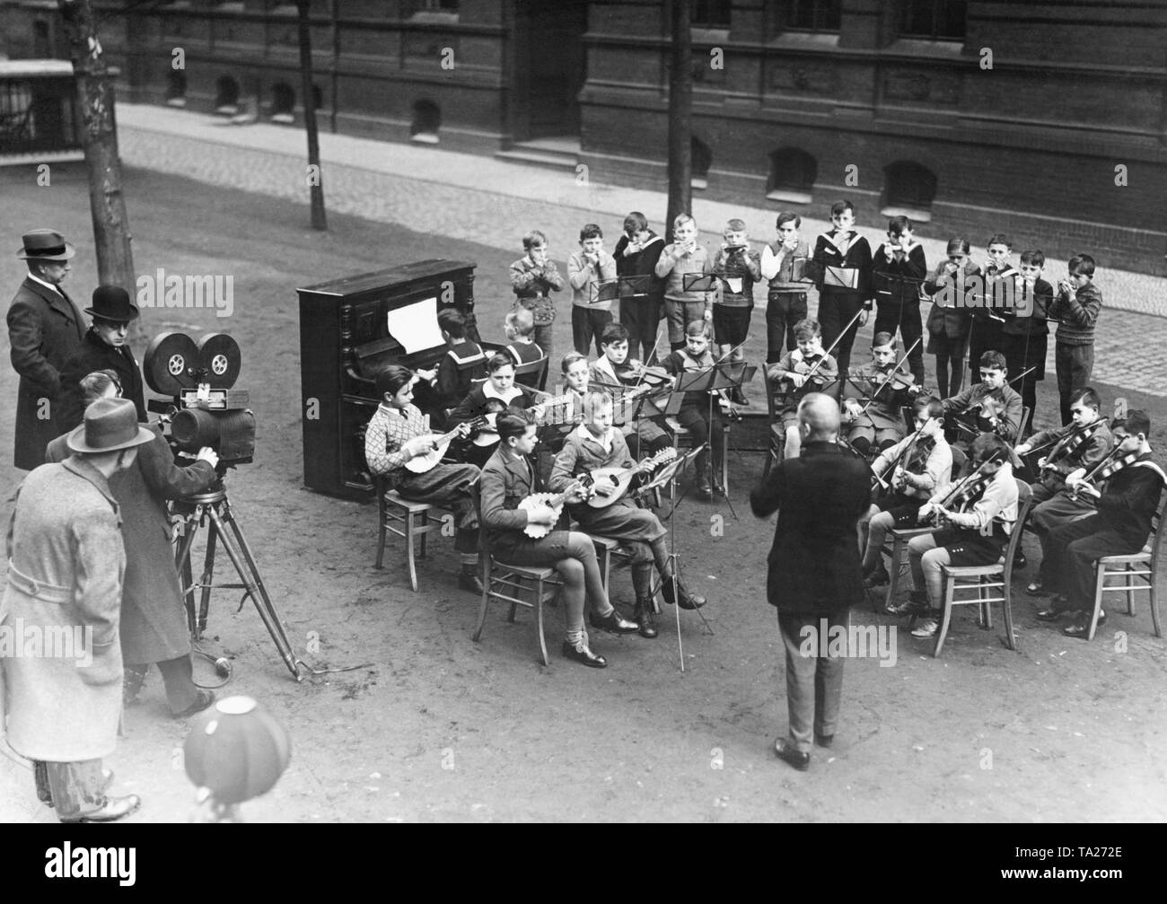 L 'UFA-Wochenschau' tire un orchestre de l'école à Berlin. Sur la gauche, l'équipe du film de l'UFA. Banque D'Images