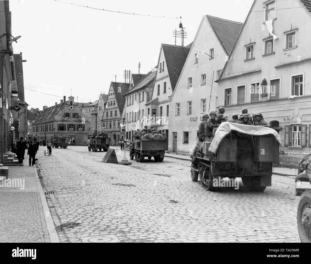 Les Américains (20e Division d'infanterie, XV, 7e Corps d'armée US) envahir Aichach. Des drapeaux blancs sont suspendus depuis les fenêtres. Banque D'Images