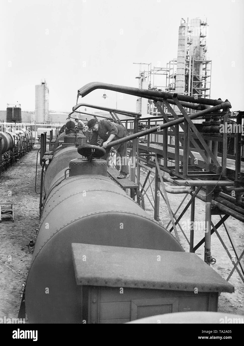L'huile de lubrification d'huile la production en Allemagne est rempli dans les voitures de la Reichsbahn. Dans l'arrière-plan, la raffinerie. Banque D'Images