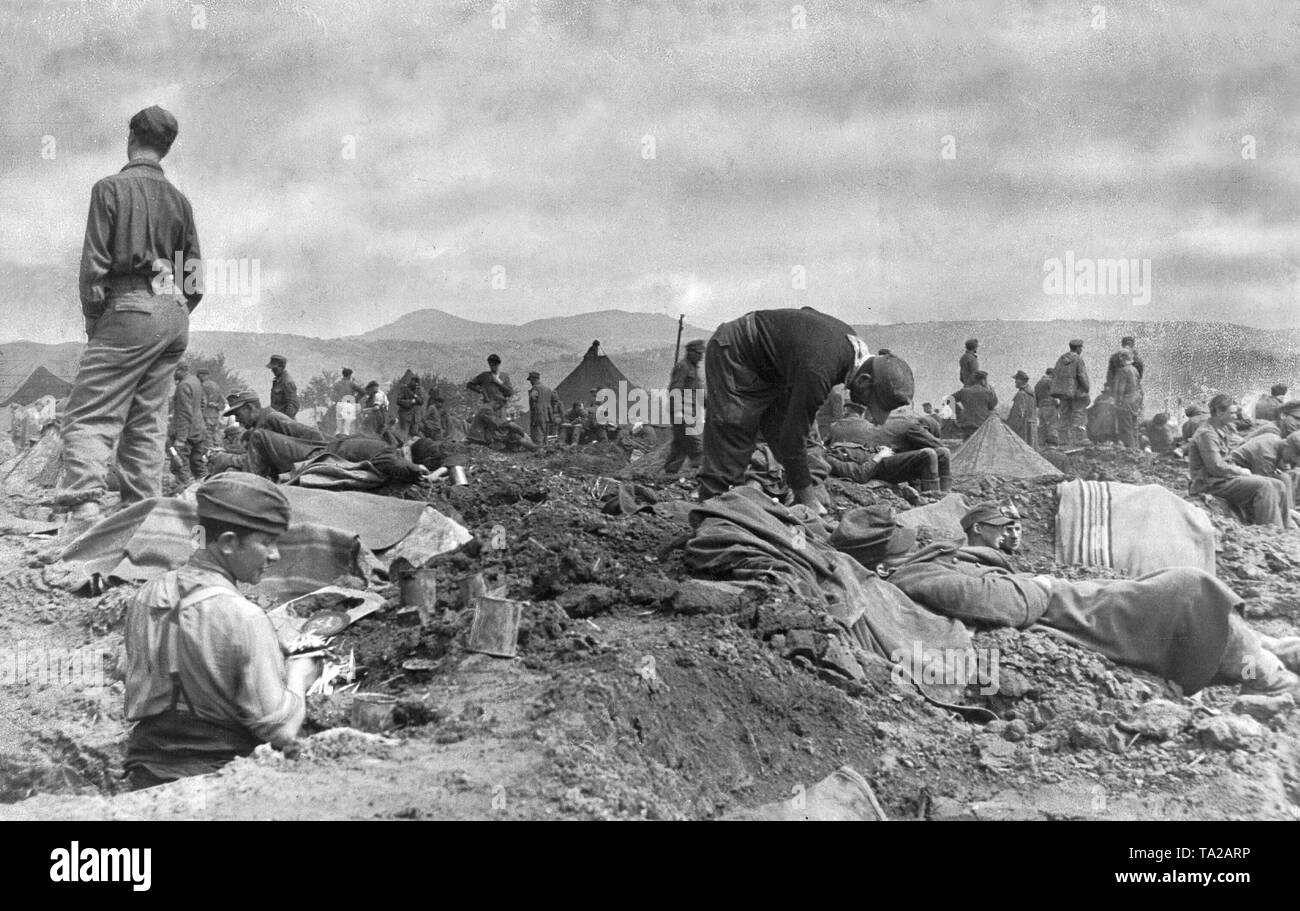 Soldats allemands dans un camp de fortune, à Remagen. Les prisonniers n'ont aucun abri contre les intempéries, juste des trous dans le sol et des couvertures. Banque D'Images