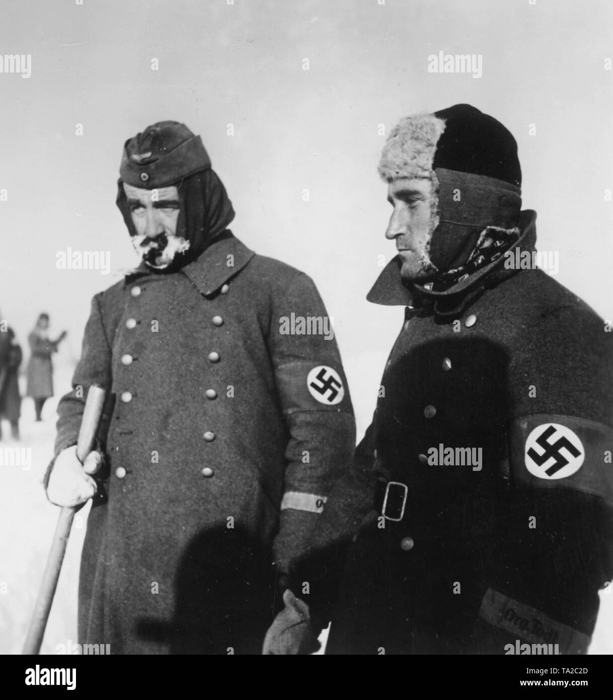 Deux hommes de l'organisation Todt ont la tâche de garder les rues de la neige au cours d'un emploi de main-d'œuvre sur le front de l'est dans l'Union soviétique. correspondant de guerre : Blenck. Banque D'Images